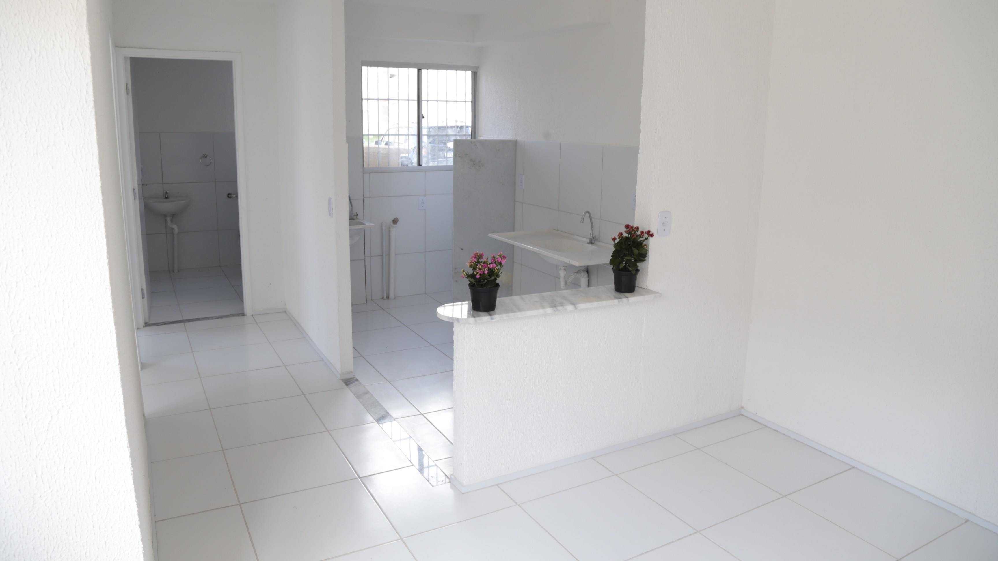 a foto mostra uma sala e uma cozinha de um apartamento recém-construído